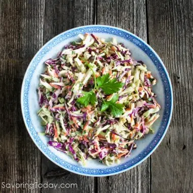 Rainbow slaw in a white bowl with a blue rim.