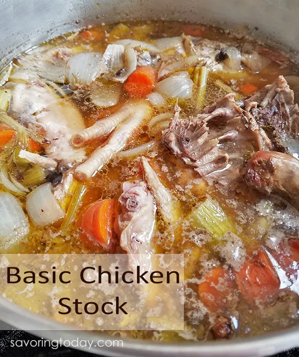 Basic Chicken Stock with bones, vegetables and chicken feet in a stainless steel pot.