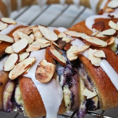 Blueberry Danish topped with icing and toasted almonds.