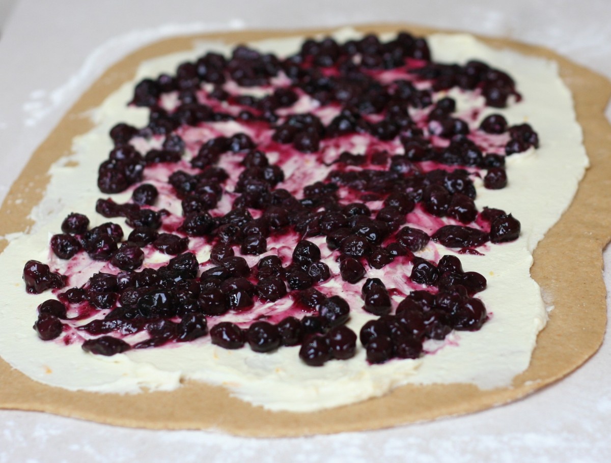 Blueberries and cream cheese spread on dough