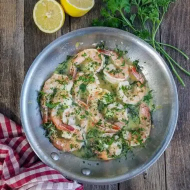 Shrimp Scampi in a skillet with lemon and parsley to show the recipe ingredients.