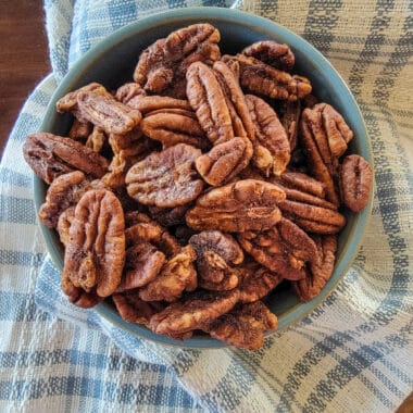 dehydrated pecans in a blue bowl on blue and white towel