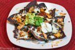 Blue tortilla chips with melted cheese, black beans, and chicken.