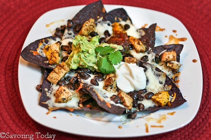 Blue tortilla chips with melted cheese, black beans, and chicken.