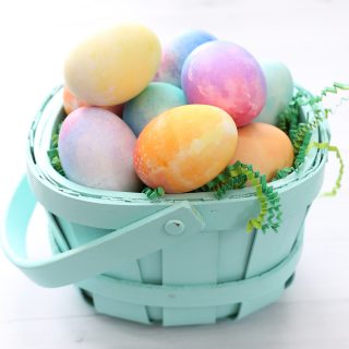 Ester eggs dyed with Kool-Aid in a green basket.