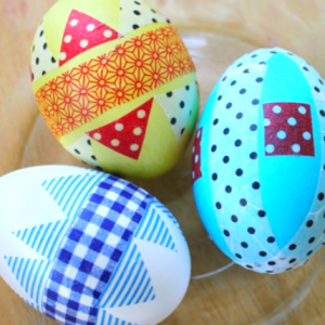 Easter eggs decorated with plaid and strips created with washi tape.