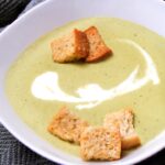 asparagus soup with croutons in a white bowl