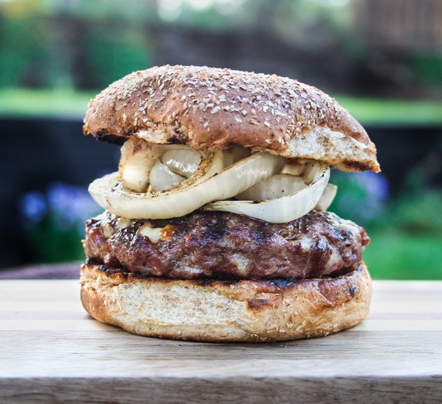 Burger with grilled onions on a whole wheat bun.