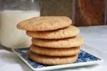 Soft, chewy snickerdoodle cookies on a small plate with milk.