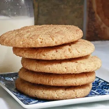 Soft, chewy snickerdoodle cookies on a small plate with milk.