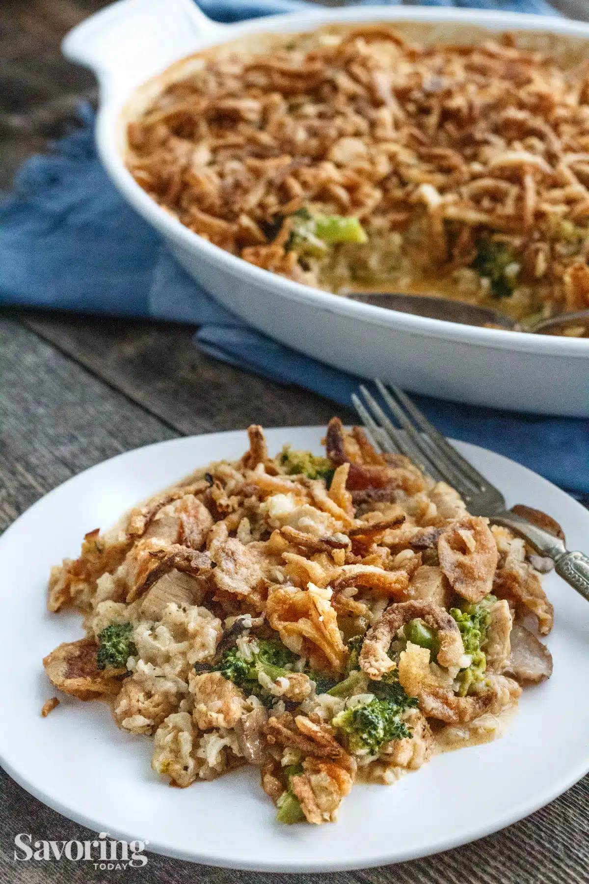 chicken broccoli casserole served on a white plate by the casserole dish