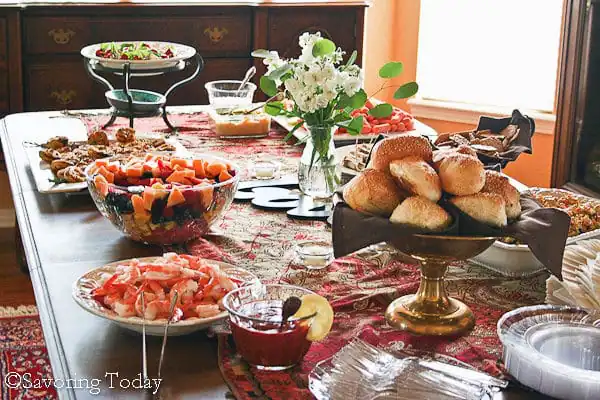 A bridal shower buffet table with shrimp, melon salad, sesame rolls, and a veggie tray.