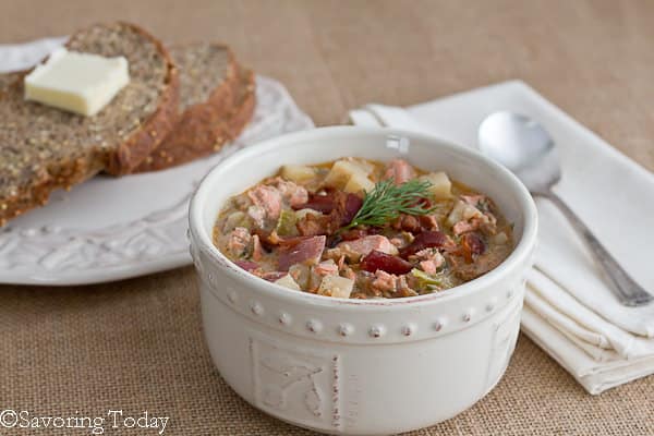 Salmon Dill Chowder in a white bowl with bread and butter on the side. 