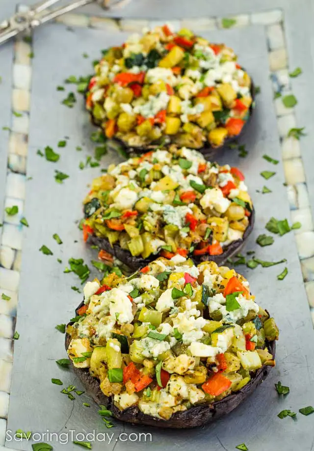 Stuffed portabella mushrooms on a blue metal platter.