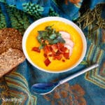 curry butternut soup in a bowl on a blue scarf