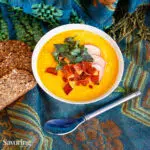 curry butternut soup in a bowl on a blue scarf
