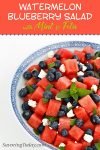 Watermelon and blueberry salad with mint and feta in a white bowl with blue trim.