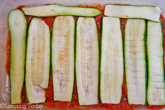 zucchini sliced for lasagna in a pan with sauce