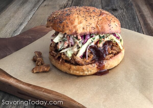 A Grilled Pulled Pork Sandwich on a wood cutting board