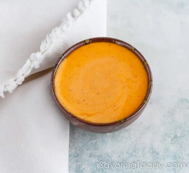 Gochujang aioli in a glazed stoneware bowl with a white napkin. 