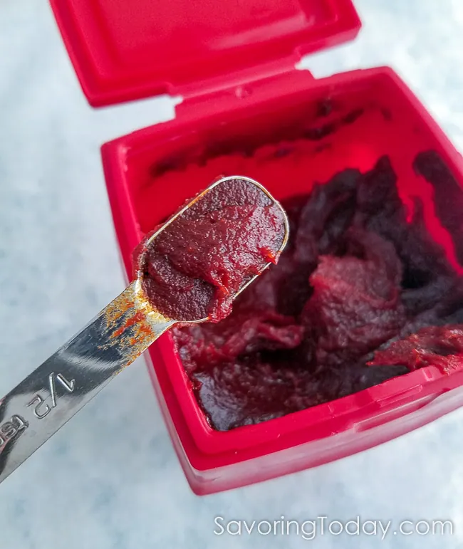 Gochujang Korean Red Chile Paste container with a teaspoon scooped out for a closeup.