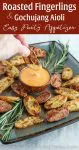 Roasted fingerling potatoes on a teal plate with dipping sauce.