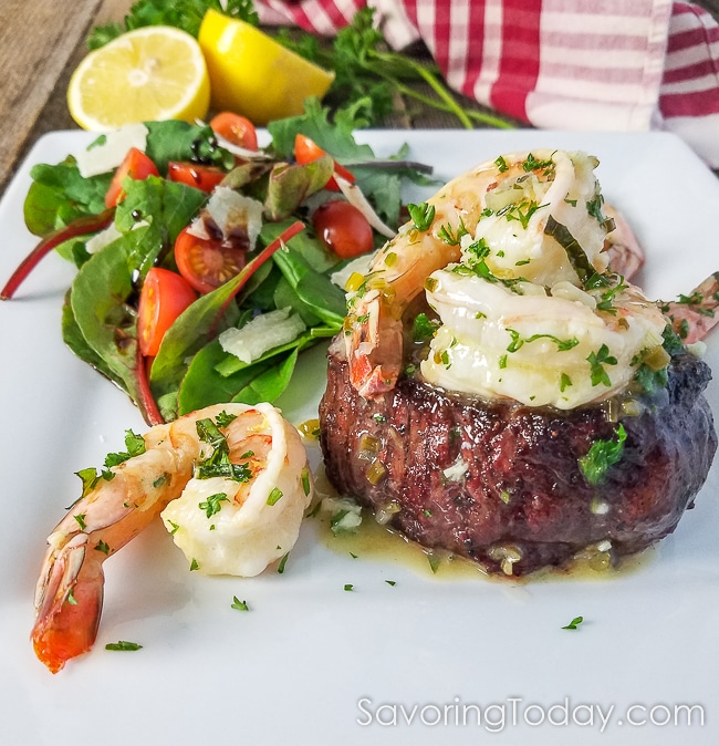 Grilled steak tenderloin topped with shrimp scampi and served with a garden salad.
