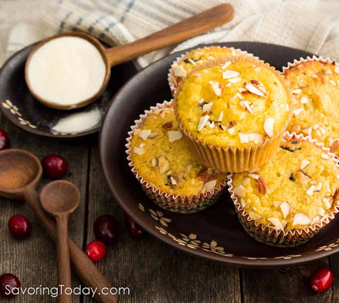 Cranberry Orange muffins on a brown plate with collagen protein powder at the side.