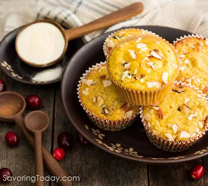 Cranberry Orange muffins on a brown plate with collagen protein powder at the side.