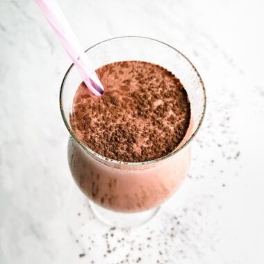 Salted mocha almond breakfast smoothie with a pink striped straw.