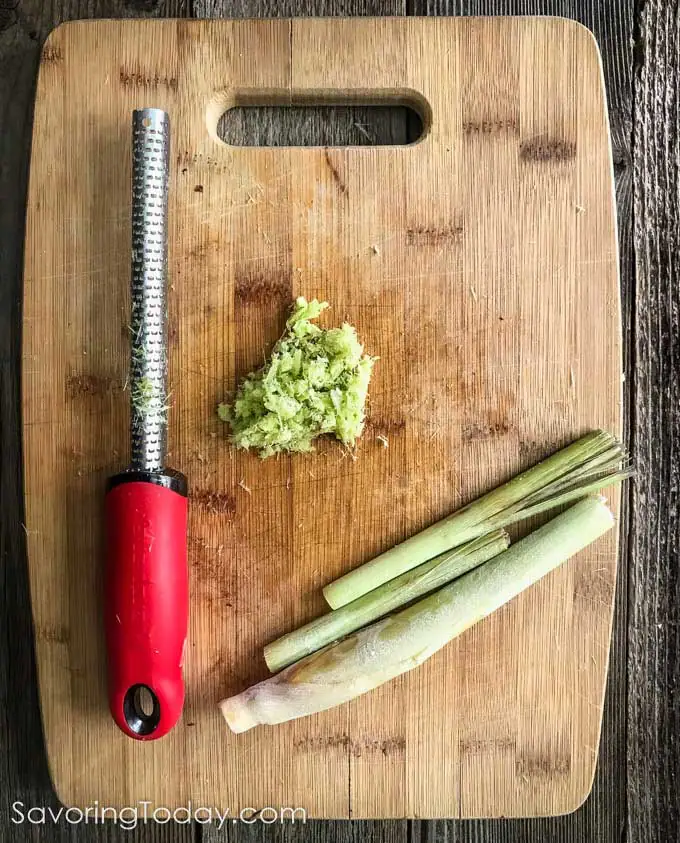 Grated lemongrass using a microplane on a cutting board.
