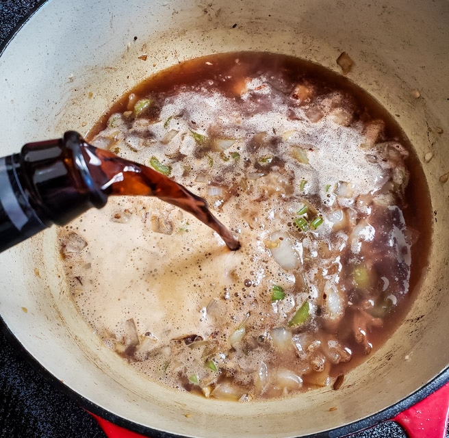 Pouring Guinness Nitro Stout in a pot of beef stew.