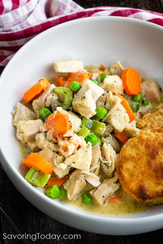 Turkey pot pie served with biscuit in a white bowl.