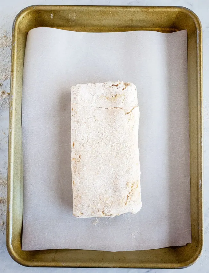 Biscuit dough folded and placed on a parchment-lined pan.