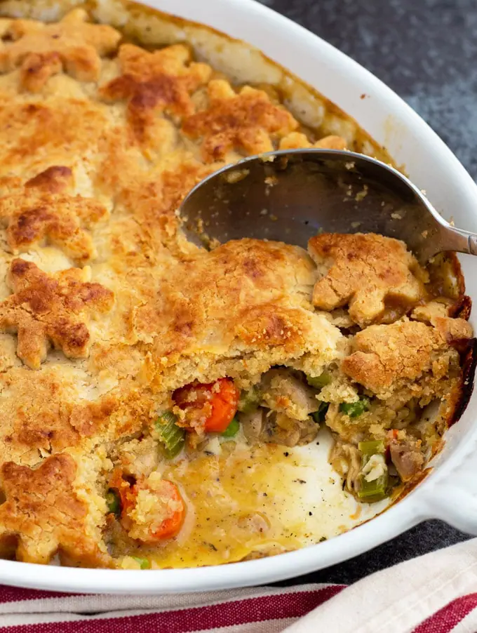 Turkey Pot Pie casserole with one serving gone showing a close up of the filling and crust.