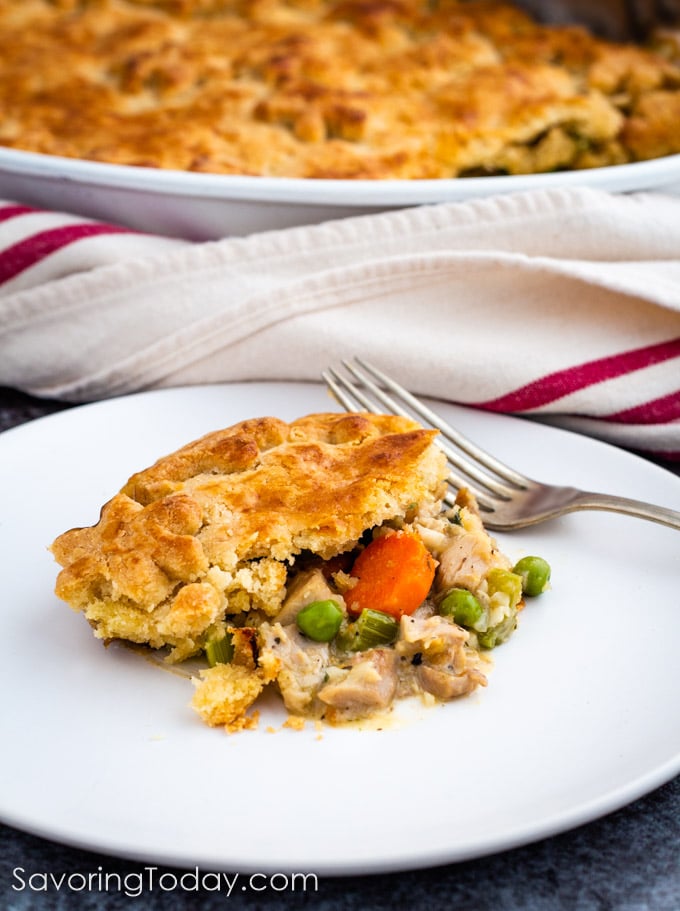 Turkey Pot Pie served on a white plate with a fork staged in front the casserole dish.