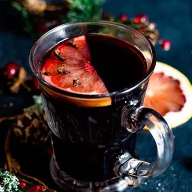 Mulled wine in a clear glass mug with grapefruit