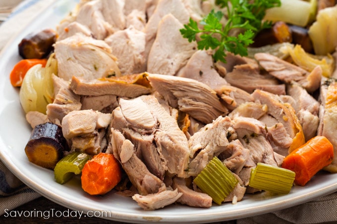 Sliced turkey on a platter with carrots and celery.