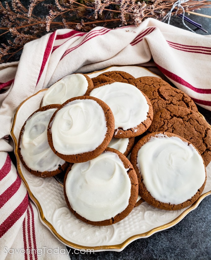 Iced molasses cookies on a plate with a red striped towel. 