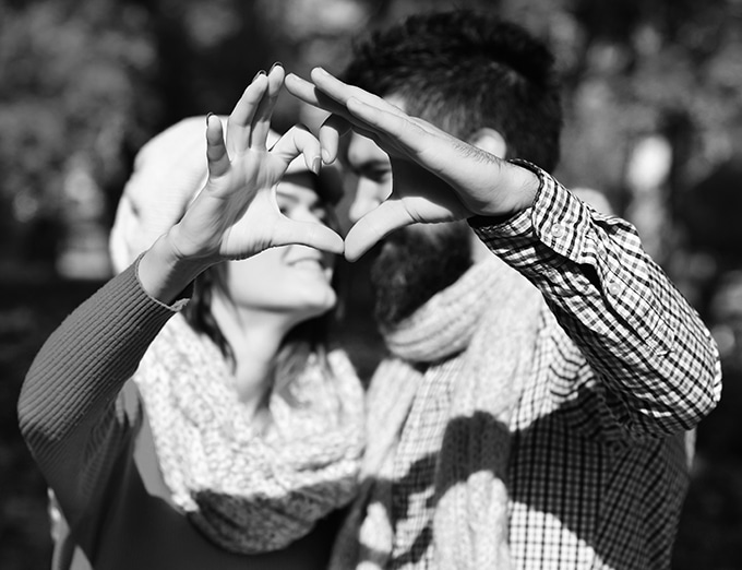 Couple holding up their hands to form a heart.