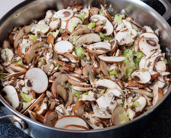 Mushrooms, onion, and celery in a skillet.
