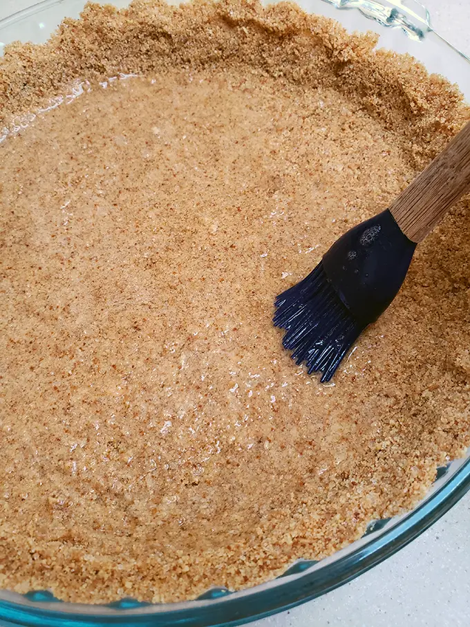 brushing egg white on graham cracker crust before baking