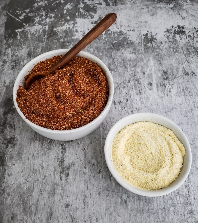 Chili seasoning and masa harina flour in bowls.