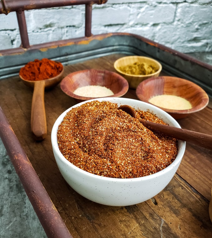 a bowl of chili seasoning mix on a tray with individual spices