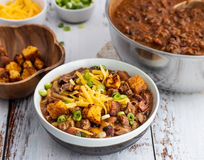 beef and bean chili in a bowl beside a soup pot