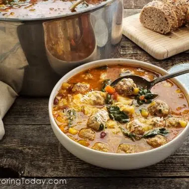 minestrone soup in a bowl iin front of the pot