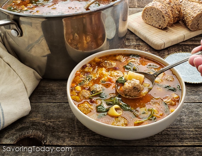 Minestrone meatball soup with a spoonful scooped up