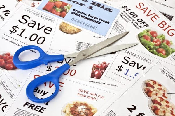 coupons spread out on a table with scissors