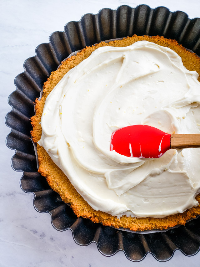 spreading cream cheese layer on a tart crust