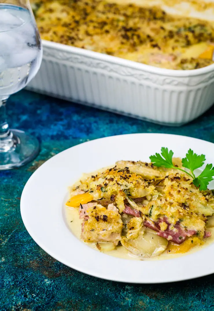 ham and vegetable casserole on a plate in front of the oven dish